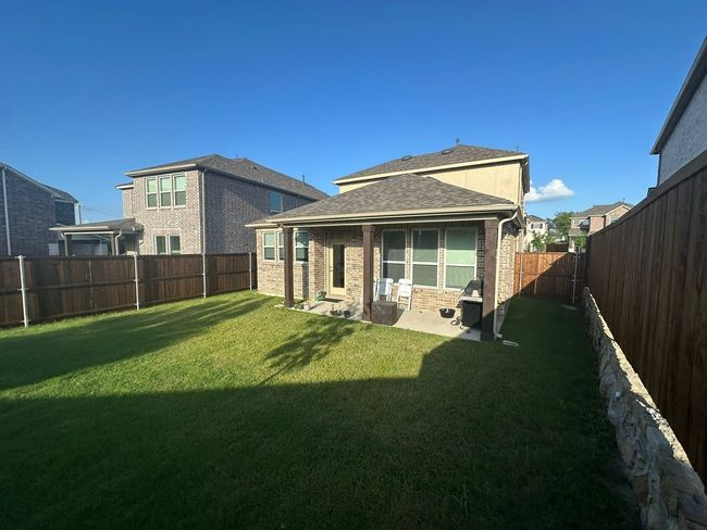 Rear view of property featuring a patio, a fenced backyard, brick siding, and a shingled roof | Image 26