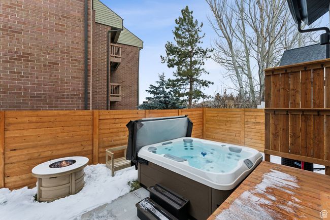 Snow covered patio featuring an outdoor fire pit, a hot tub, and a wooden deck | Image 42