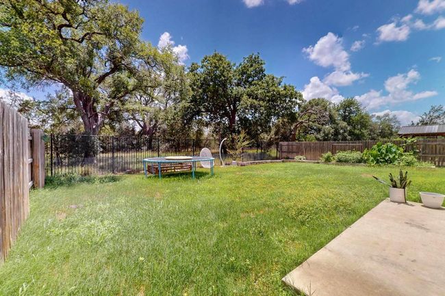 Fenced backyard featuring a trampoline | Image 23