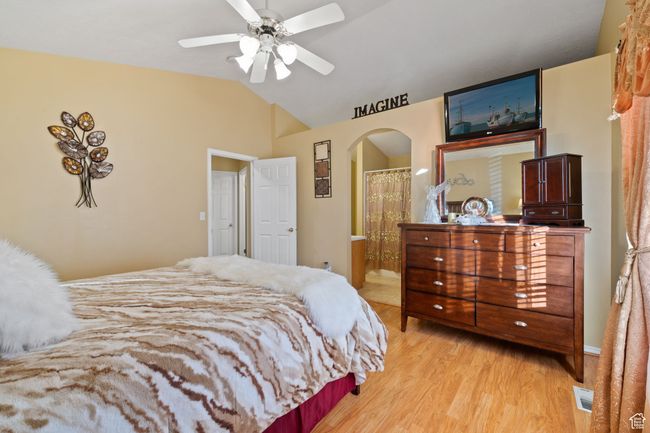 Bedroom with connected bathroom, vaulted ceiling, and light wood-type flooring | Image 18