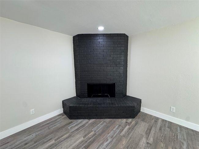 Details with a brick fireplace, baseboards, and wood finished floors | Image 7