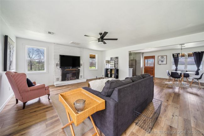 Living room featuring plenty of natural light, light wood finished floors, ceiling fan, and baseboards | Image 14
