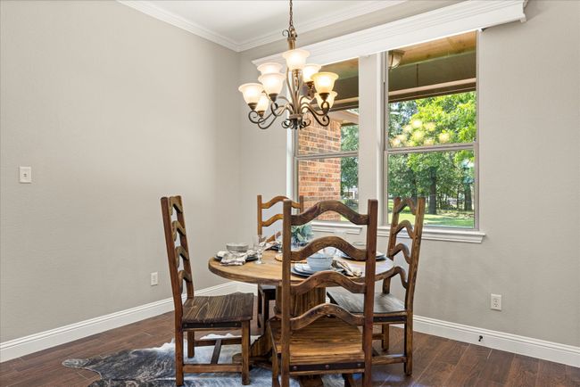 Dining space featuring a chandelier, dark wood-style floors, healthy amount of natural light, and crown molding | Image 16