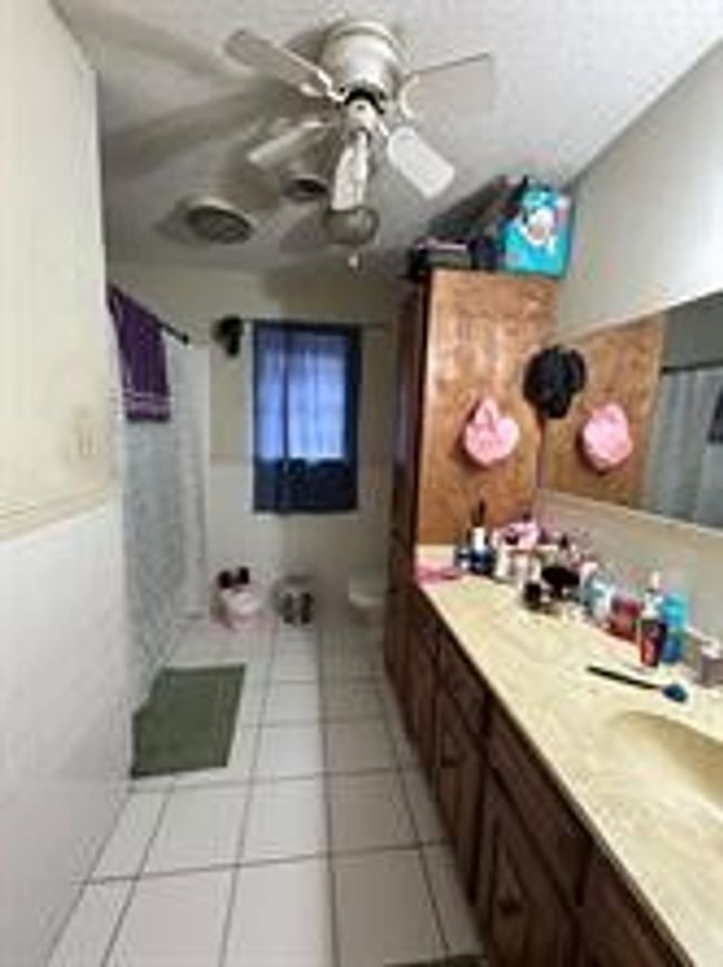 Full bath with ceiling fan, vanity, toilet, and tile patterned floors | Image 13