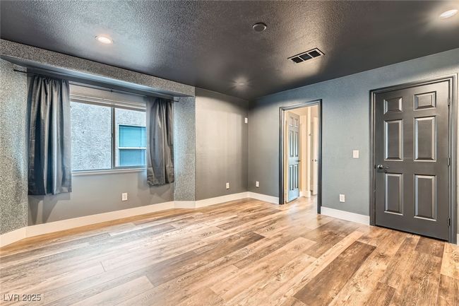 Unfurnished room with wood finished floors, a textured ceiling, a textured wall, and recessed lighting | Image 29
