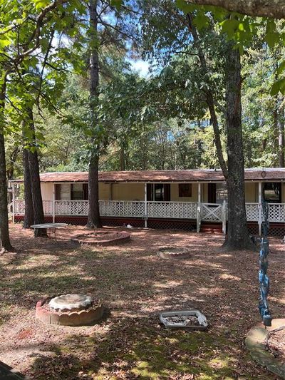 Back of house featuring covered porch and an outdoor fire pit | Image 3