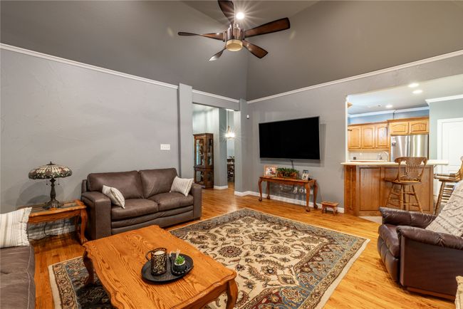 Living room with ceiling fan, high vaulted ceiling, and light wood-style flooring | Image 12