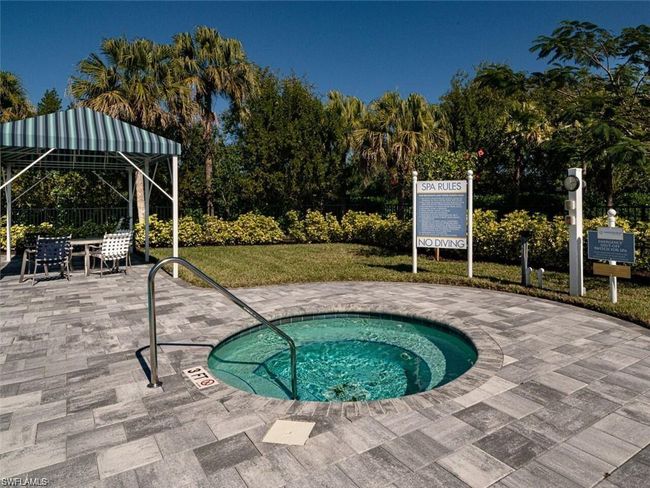 View of swimming pool featuring a lawn, a hot tub, and a patio area | Image 22