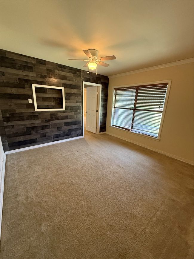 Featuring ceiling fan, wood look covered wall, carpet, and molding, ceiling fan | Image 6