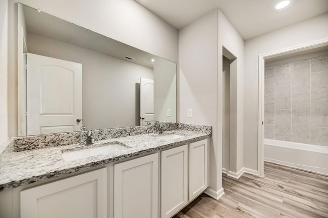 Bathroom featuring baseboards, wood finished floors, a sink, and double vanity | Image 12