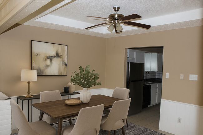 Dining area with wainscoting, a ceiling fan, light tile patterned floors, and a textured ceiling | Image 9