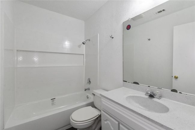 Secondary bathroom, located off the living room and next to the two secondary bedrooms. New tub installed, tile replaced, and cabinet painted in February 2022. | Image 20
