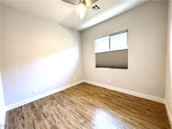 Unfurnished room with wood finished floors, visible vents, ceiling fan, and baseboards | Image 28