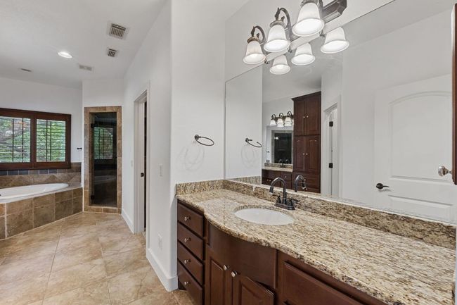 Bathroom with vanity, a stall shower, a garden tub, and tile patterned flooring | Image 31