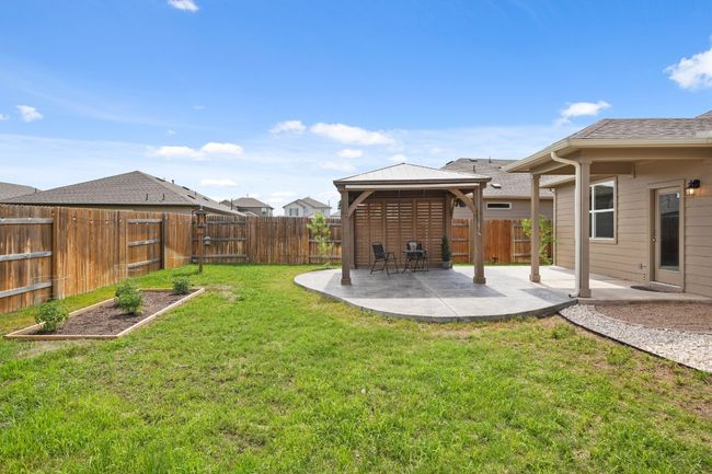 View of yard featuring a gazebo, a patio area, and a vegetable garden | Image 24