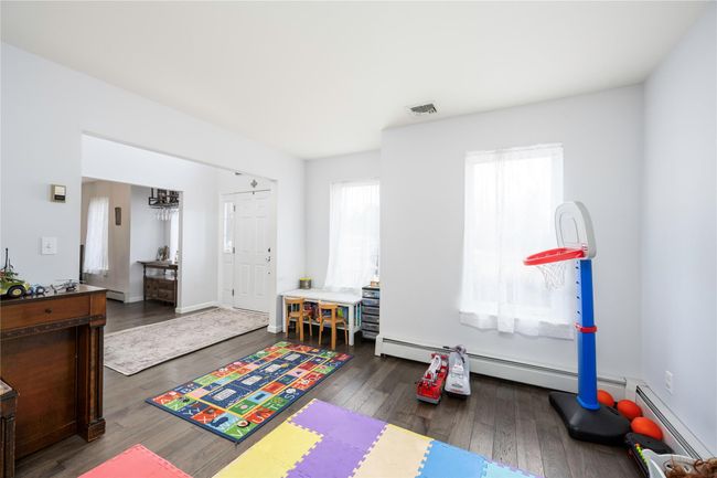 Rec room featuring a baseboard heating unit and hardwood / wood-style floors | Image 13
