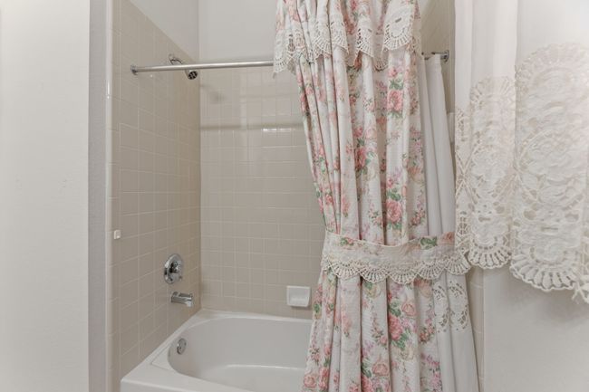 Bathroom featuring shower / bathtub combination with curtain | Image 35