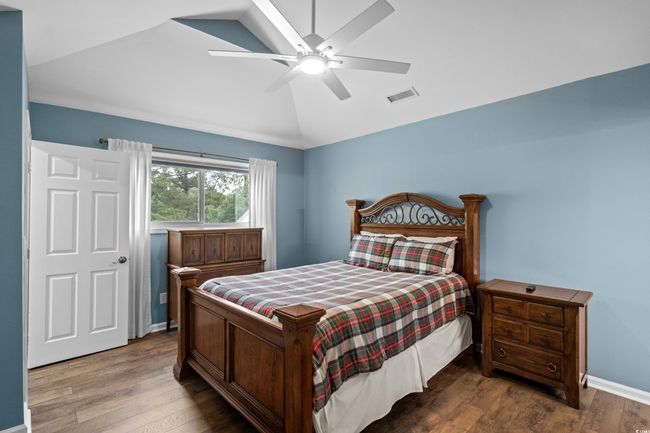 Bedroom with vaulted ceiling, wood finished floors, a ceiling fan, and baseboards | Image 16