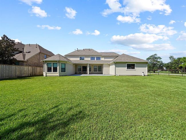Spacious covered patio with a fan, offering a stunning view of the expansive backyard! Plenty of space to create your own backyard oasis with a pool! | Image 47