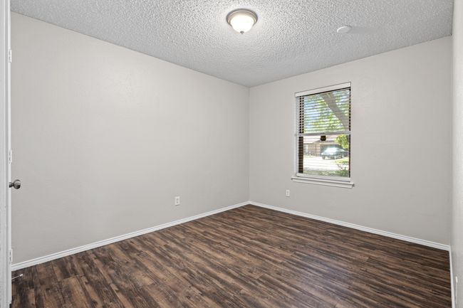 Spare room with dark wood finished floors, baseboards, and a textured ceiling | Image 15