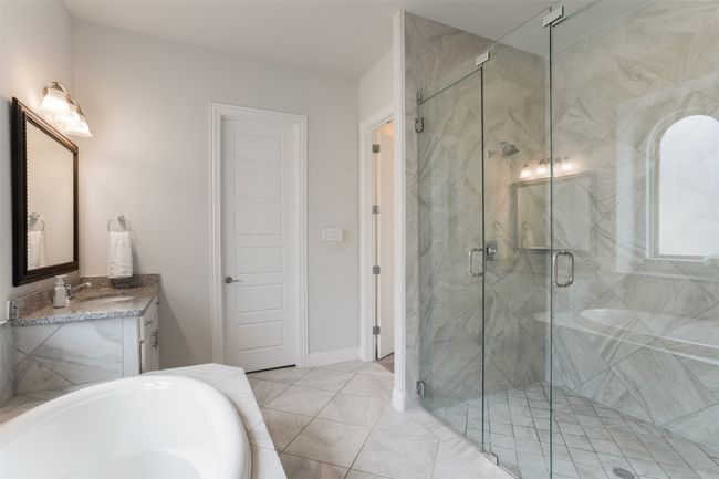 Full bathroom with a tub to relax in, a marble finish shower, and vanity | Image 23