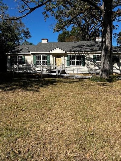 View of front of property featuring a wooden deck and a front yard | Image 1