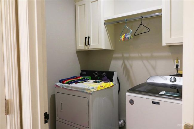 Clothes washing area with washing machine and clothes dryer and cabinet space | Image 18