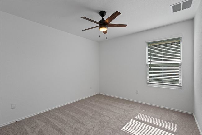 Carpeted empty room with ceiling fan and baseboards | Image 20
