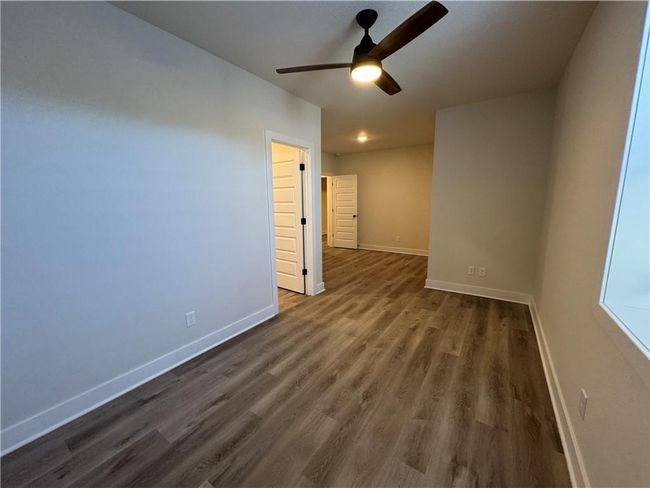Unfurnished room with ceiling fan and dark wood-type flooring | Image 60