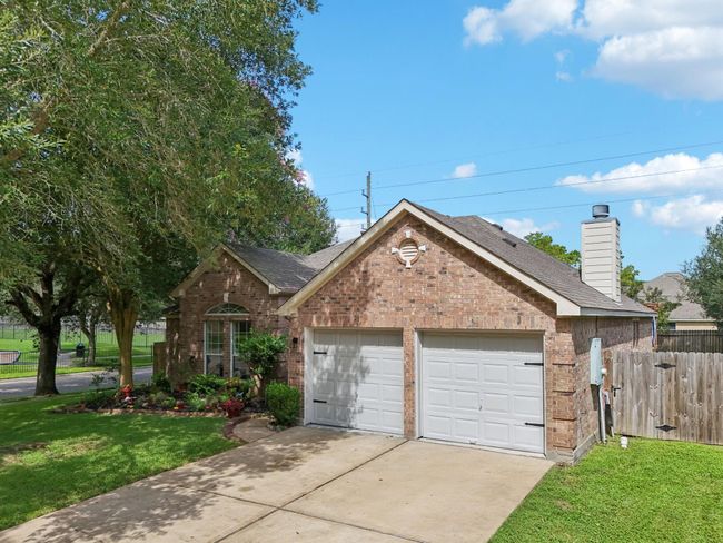 Charming single-story brick home with a two-car garage, situated on a corner lot. Features a well-maintained lawn, mature trees, and a fenced backyard. The exterior is inviting with a cozy, suburban feel. | Image 29
