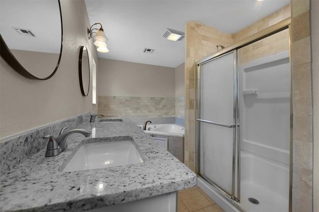 Bathroom featuring double vanity, an enclosed shower, and tile patterned floors | Image 23