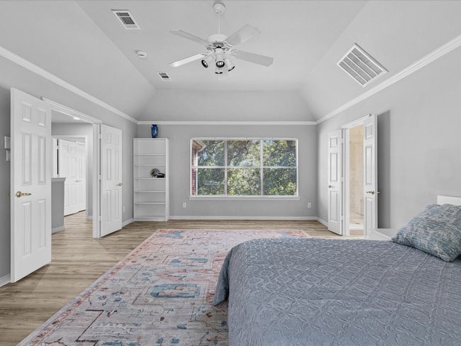 Master bedroom featuring laminated floors, vaulted ceiling, and a ceiling fan | Image 22