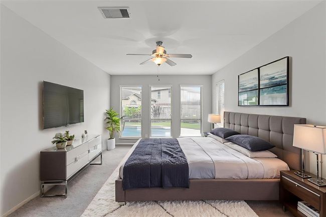 Virtually Staged: Unwind after a long day in this incredibly spacious Primary Bedroom! Featuring lots of natural light, plush carpet, privacy blinds, and a ceiling fan. | Image 11