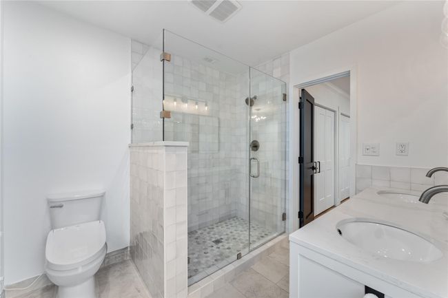 Quartz countertops and polished hexagon marble shower flooring | Image 16