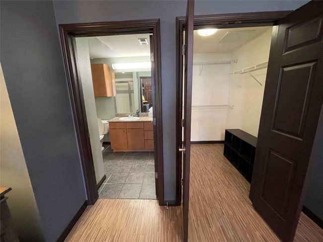 Full bath featuring vanity, a shower with shower door, a spacious closet, and baseboards | Image 13