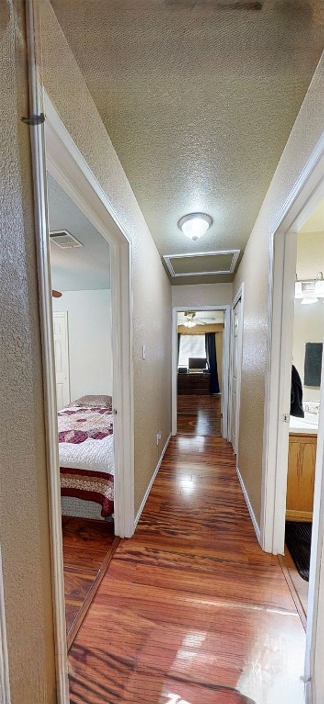 Hall with wood finished floors, attic access, a textured wall, and a textured ceiling | Image 20