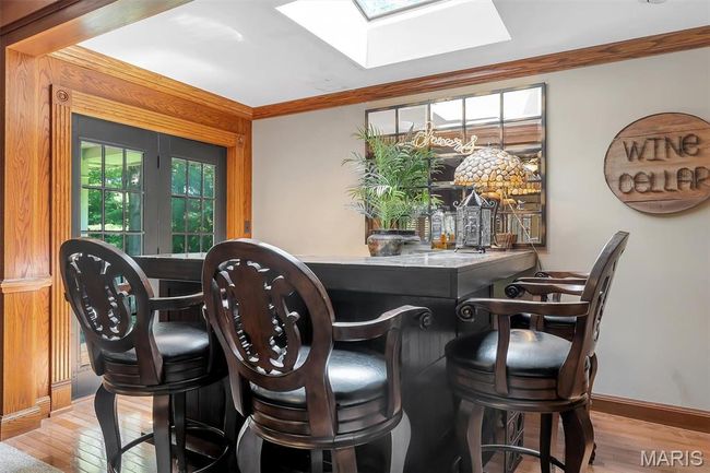 Bar area with a skylight, wood-type flooring, and ornamental molding | Image 54