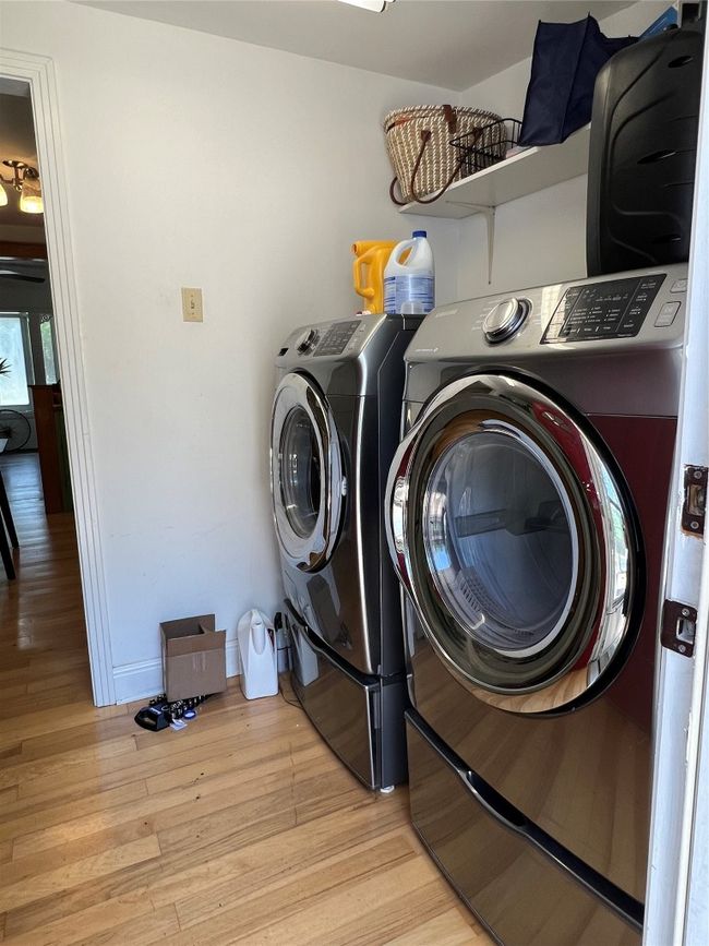 Washroom featuring washer and clothes dryer, light wood-type flooring, laundry area, and baseboards | Image 19