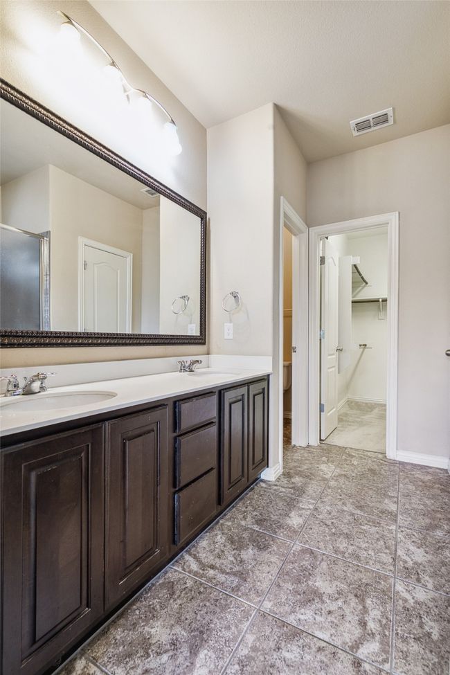 Bathroom featuring double vanity, toilet, tile patterned flooring, and a closet | Image 23