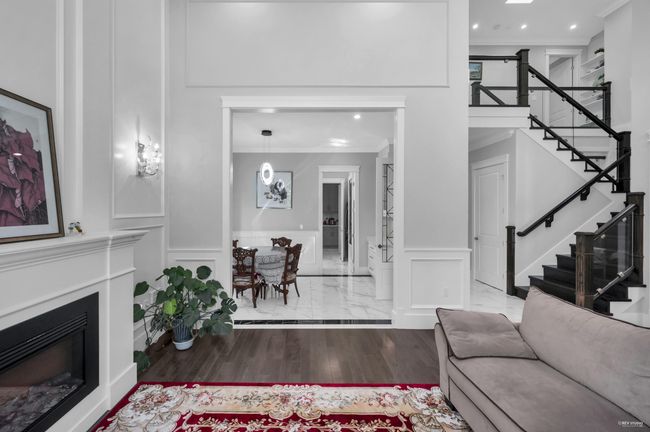 Living area with a decorative wall, stairway, wainscoting, recessed lighting, and ornamental molding | Image 8