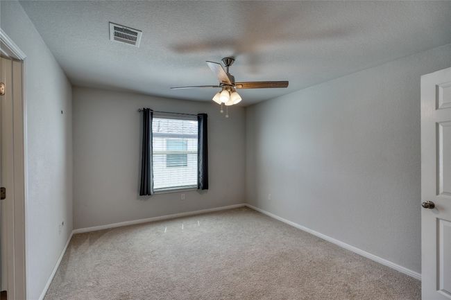 Carpeted spare room featuring baseboards, a ceiling fan, visible vents, and a textured ceiling | Image 31