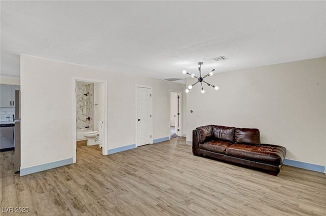 Living area with a chandelier and light wood finished floors | Image 6