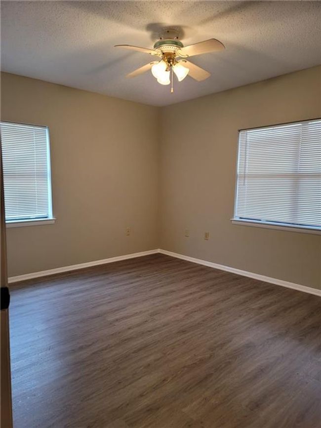 Spare room featuring a ceiling fan, dark wood-style floors, and a textured ceiling | Image 14