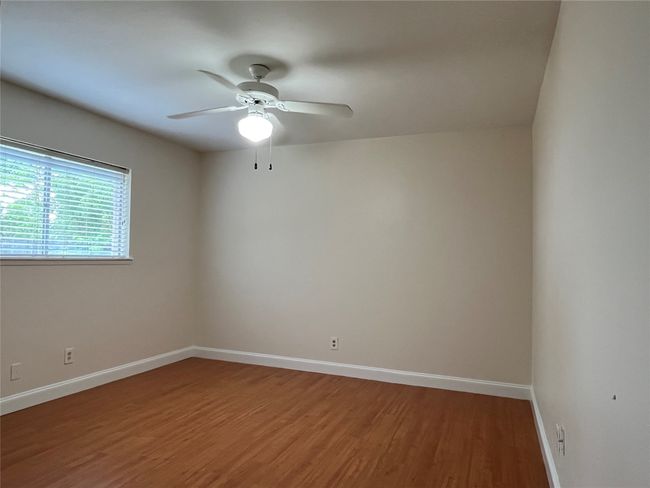 Spare room with light wood-type flooring, baseboards, and a ceiling fan | Image 23