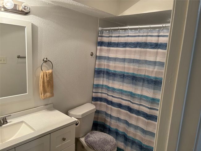 Full bath with vanity, a shower with shower curtain, and a textured wall | Image 9