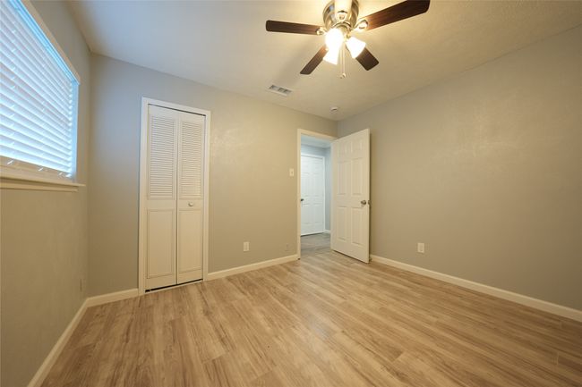 Unfurnished bedroom with baseboards, visible vents, and light wood-style flooring | Image 9