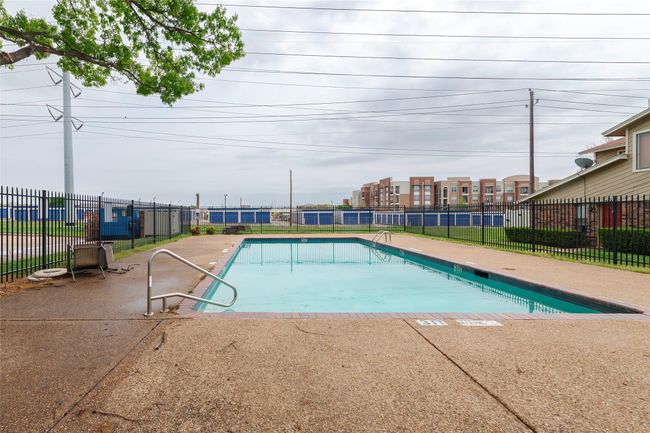 Community pool with a patio area and fence | Image 23