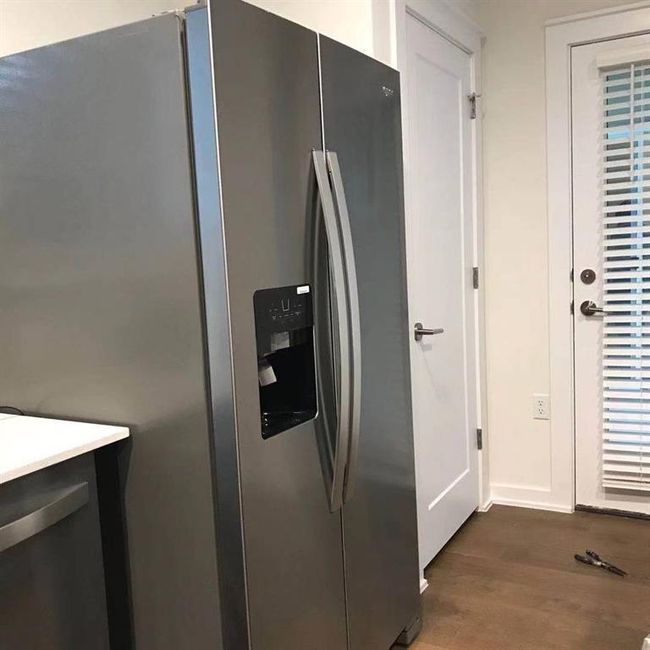 Kitchen featuring stainless steel fridge, dark wood-type flooring, and light countertops | Image 8
