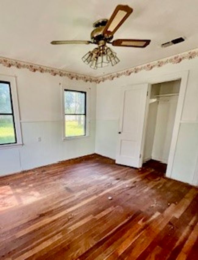 Unfurnished bedroom with hardwood / wood-style floors, a ceiling fan, and a closet | Image 6