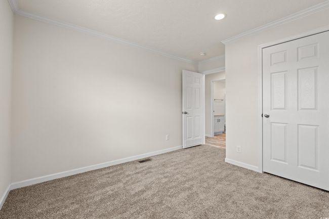 Unfurnished bedroom featuring baseboards, ornamental molding, recessed lighting, visible vents, and carpet | Image 24
